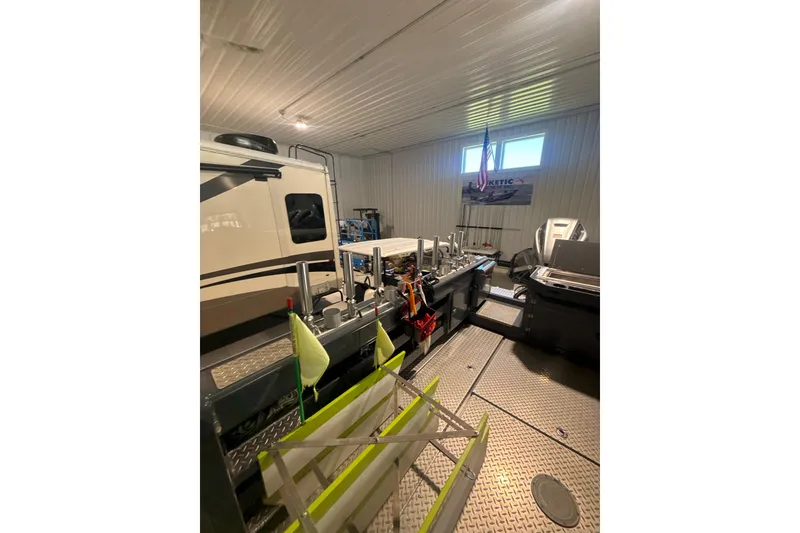Slide: The Image of 2022 Hewescraft 270 Alaskan Hardtop in a garage with equipment and tools. - 4