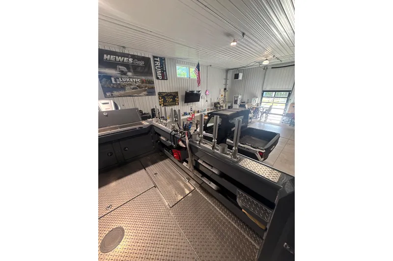 Slide: The Image of Interior of a 2022 Hewescraft 270 Alaskan Hardtop in a spacious garage setting. - 5