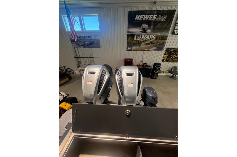 Slide: The Image of 2022 Hewescraft 270 Alaskan Hardtop with dual outboard motors in a showroom. - 7