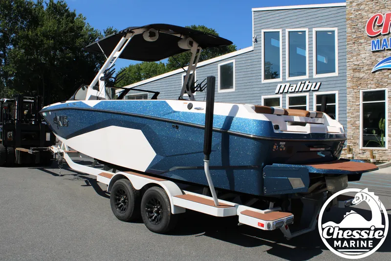 Slide: The Image of A 2025 Axis A245 boat on a trailer in front of a building. - 3