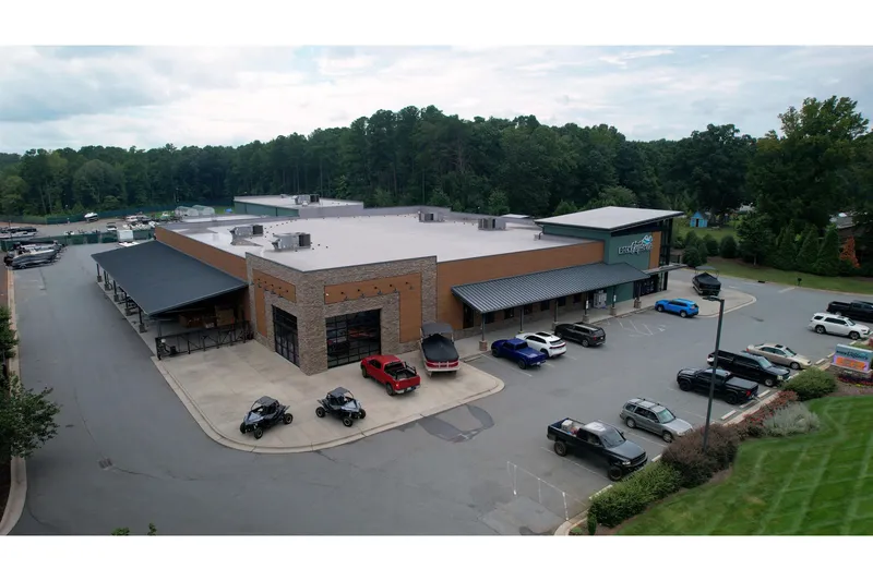 Slide: The Image of Aerial view of a commercial building with parking lot, surrounded by trees. - 12