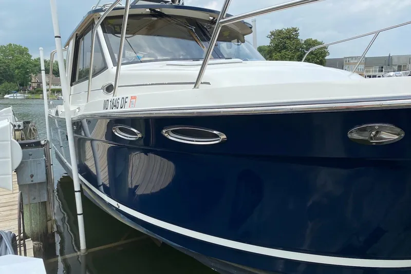 Slide: The Image of 2013 Cutwater 28 boat docked, featuring sleek blue and white design. - 10