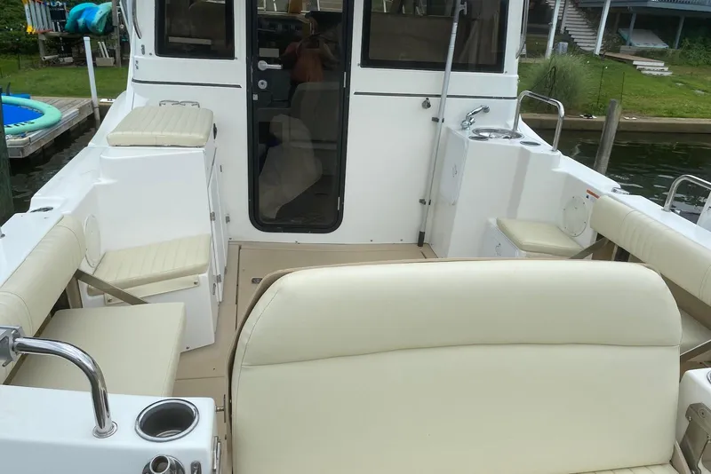 Slide: The Image of Interior view of a 2013 Cutwater 28 boat with beige seating and a compact layout. - 11