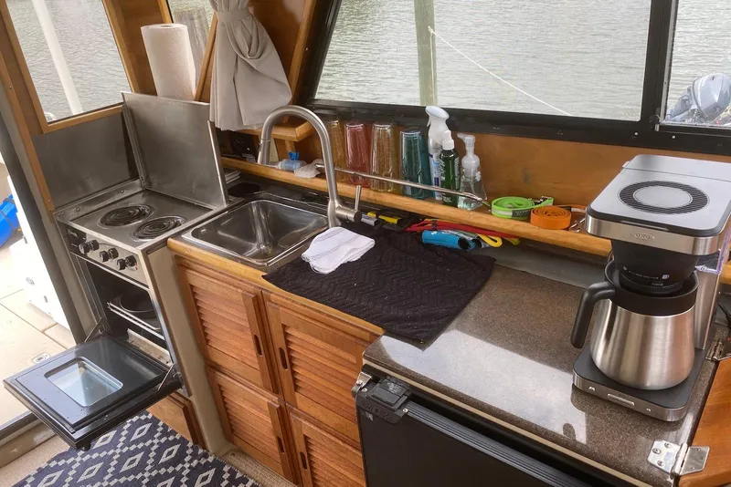 Slide: The Image of Interior of a 2013 Cutwater 28 boat kitchen with stove, sink, and coffee maker. - 14