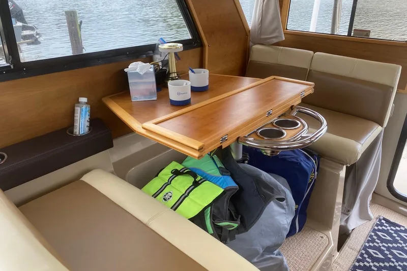 Slide: The Image of Interior of a 2013 Cutwater 28 boat with a wooden table and seating area. - 17