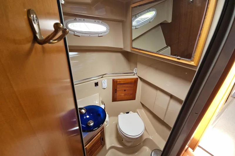 Slide: The Image of Bathroom interior of 2013 Cutwater 28 boat with blue sink and wooden accents. - 26