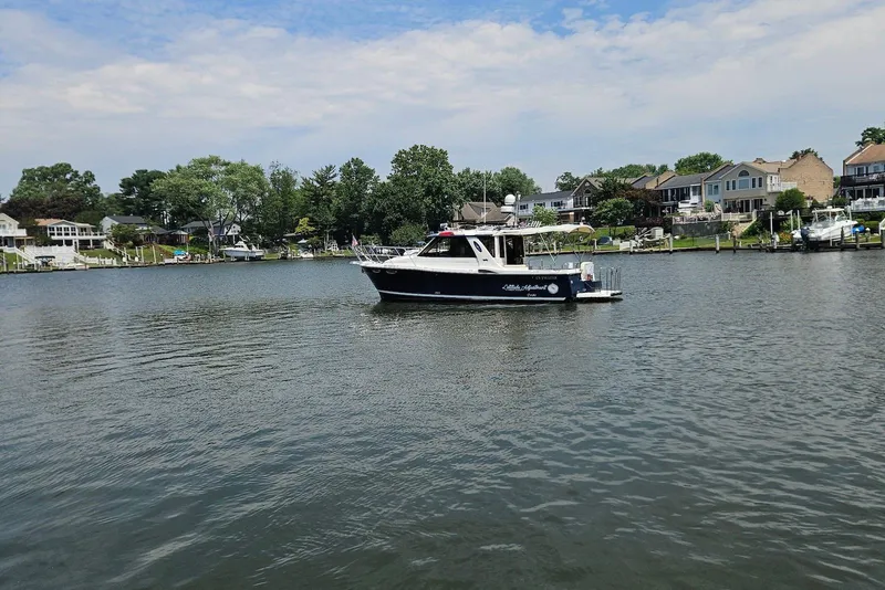 Slide: The Image of 2013 Cutwater 28 boat cruising on a calm river near residential homes. - 5