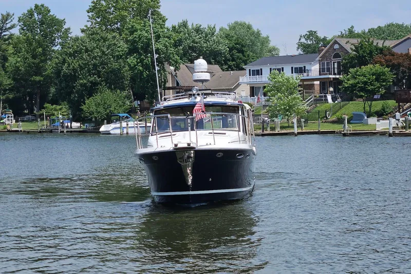 Slide: The Image of 2013 Cutwater 28 boat cruising on a serene lake near waterfront homes. - 6