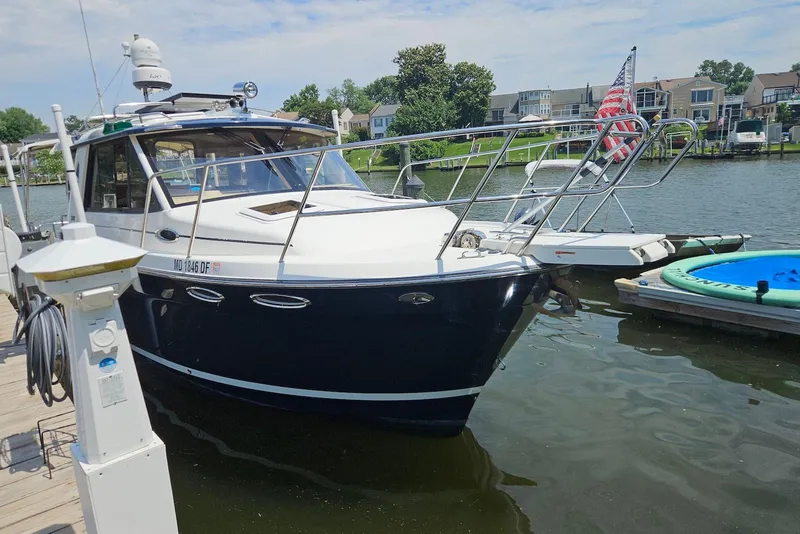 Slide: The Image of 2013 Cutwater 28 boat docked in a marina, featuring sleek design and American flag. - 7