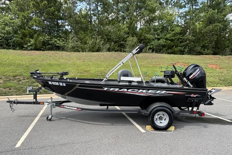 The Image of 2022 Tracker Super Guide V-16 T fishing boat on trailer in parking lot. - 1