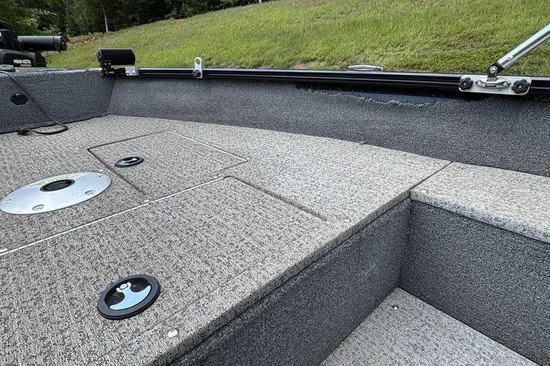Slide: The Image of Interior of 2022 Tracker Super Guide V-16 T boat with carpeted deck and storage compartments. - 12