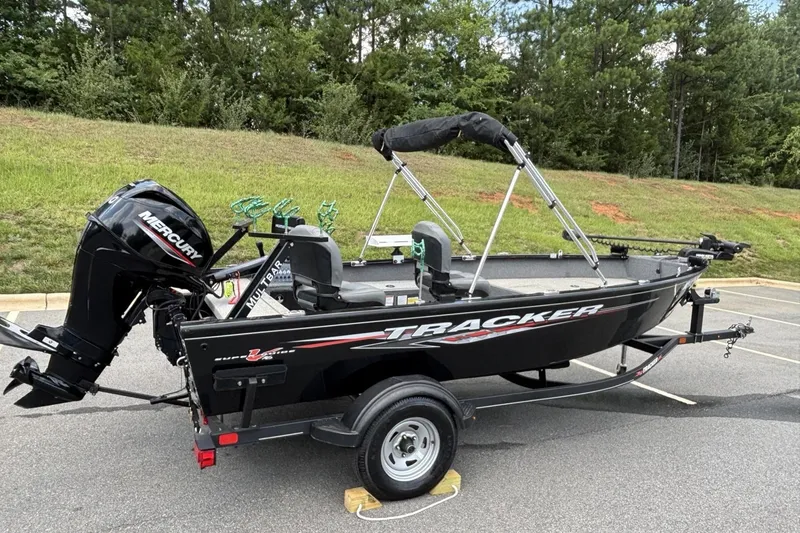 Slide: The Image of 2022 Tracker Super Guide V-16 T boat with Mercury engine on trailer, parked outdoors. - 16