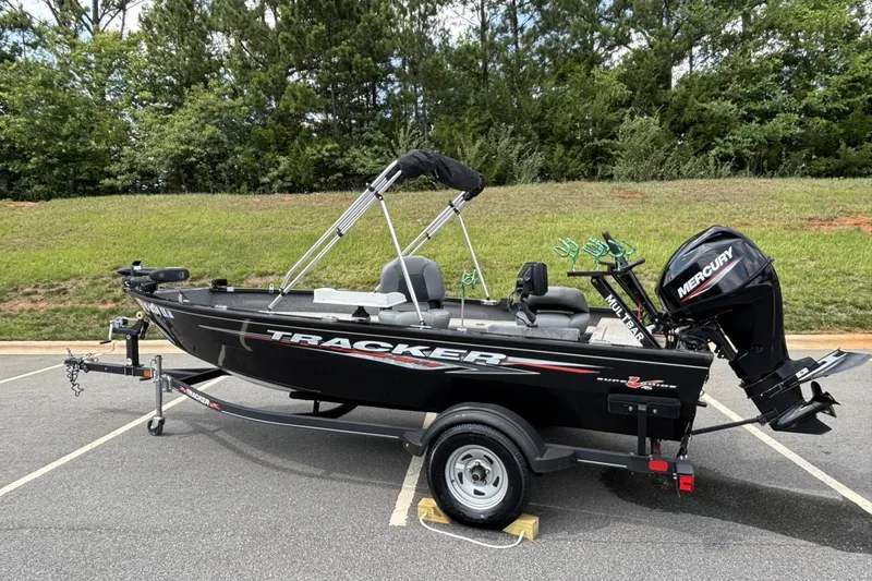 Slide: The Image of 2022 Tracker Super Guide V-16 T fishing boat with Mercury motor in a parking lot. - 3