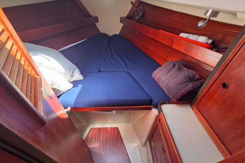 Slide: The Image of Cozy cabin interior of 1985 C&C 37 sailboat with wooden finish and blue bedding. - 10