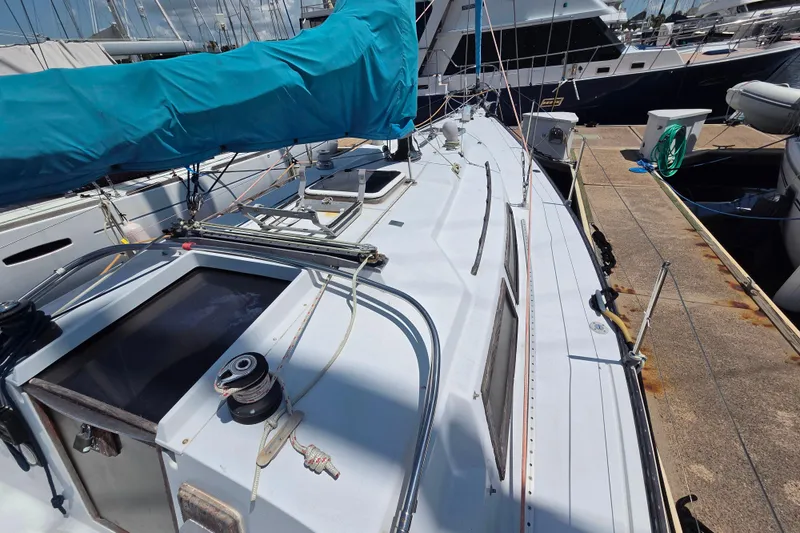 Slide: The Image of 1985 C&C 37 sailboat docked, featuring a blue sail cover and deck equipment. - 3