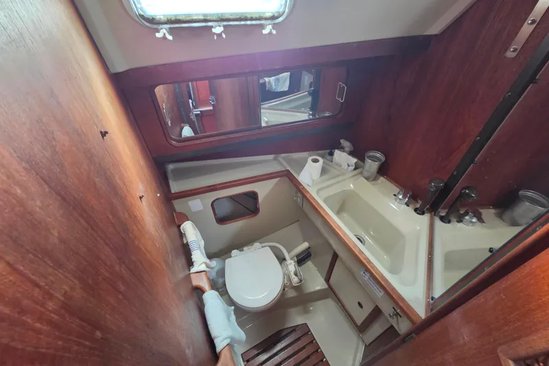 Slide: The Image of 1985 C&C 37 sailboat bathroom with wooden accents and compact fixtures. - 9