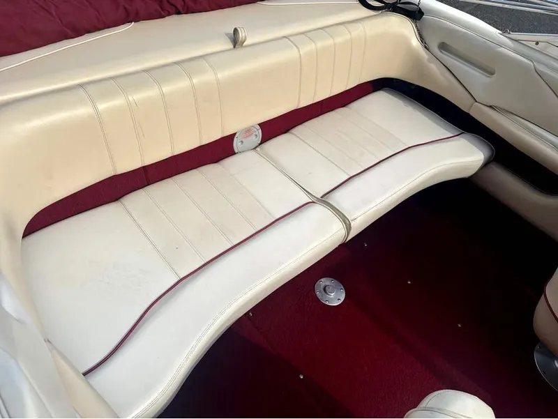 Slide: The Image of The interior of a 1996 Sea Ray 210 Signature features white leather seating with red accents. - 10