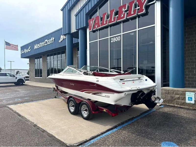 Slide: The Image of A 1996 Sea Ray 210 Signature on a trailer outside a building with large windows. - 3