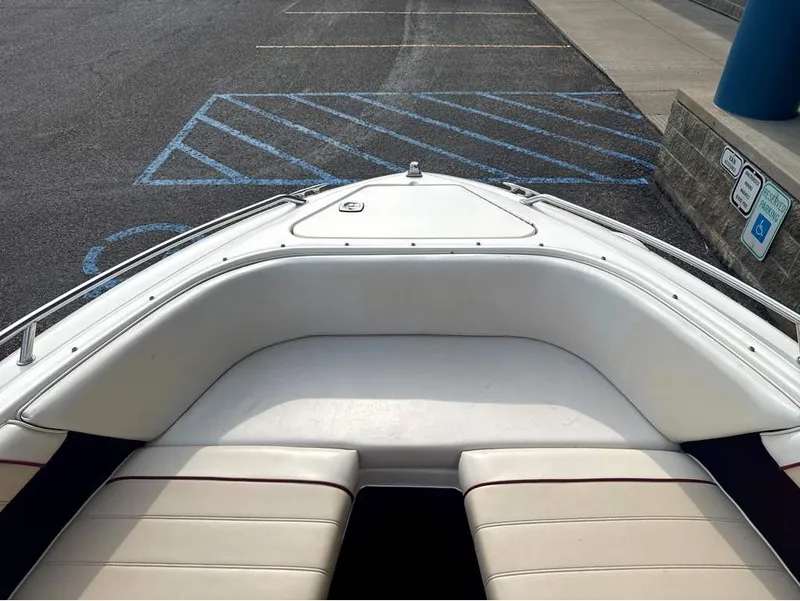 Slide: The Image of The image shows the bow of a 1996 Sea Ray 210 Signature boat with white upholstery. - 16