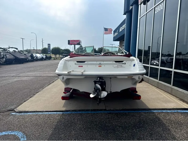 Slide: The Image of A white 1996 Sea Ray 210 Signature boat on a trailer in front of a building. - 4