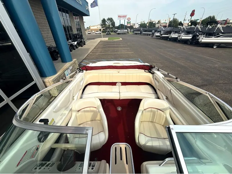 Slide: The Image of The image shows the cockpit of a 1996 Sea Ray 210 Signature boat with white seating. - 18