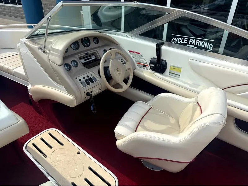 Slide: The Image of The image shows the cockpit of a 1996 Sea Ray 210 Signature with cream seats and red carpet. - 13