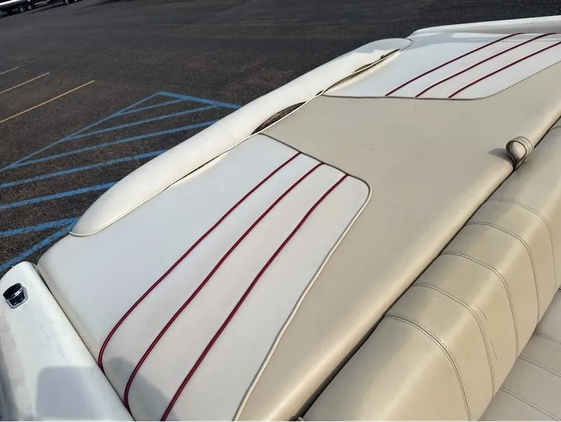 Slide: The Image of The image shows the beige upholstery of a Sea Ray 210 Signature boat with red stripes. - 9