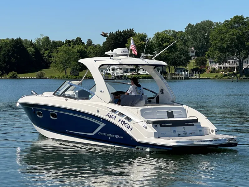 The Image of A 2016 Chaparral 337 SSX boat cruising on calm water with a green shoreline. - 0