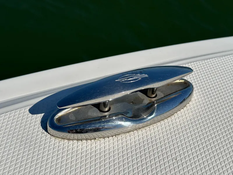 Slide: The Image of Close-up of a shiny metal cleat on a boat, surrounded by textured deck material. - 26