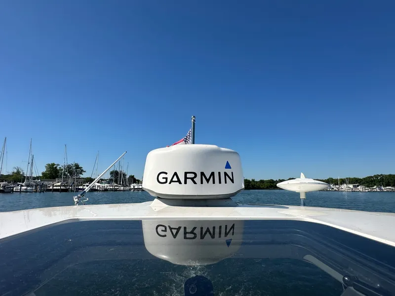 Slide: The Image of 2016 Chaparral 337 SSX with Garmin equipment, on calm water with marina in the background. - 27