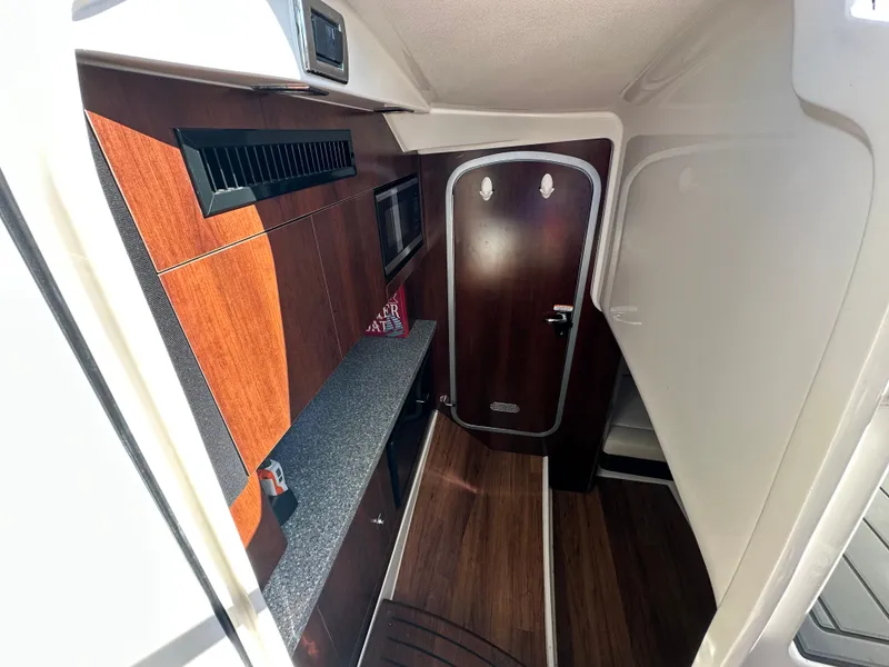 Slide: The Image of Interior of the 2016 Chaparral 337 SSX with wood flooring and sleek cabinetry. - 28