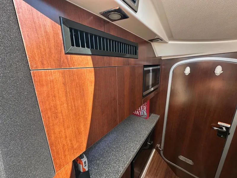 Slide: The Image of Interior of a 2016 Chaparral 337 SSX with wood paneling and a small countertop. - 29