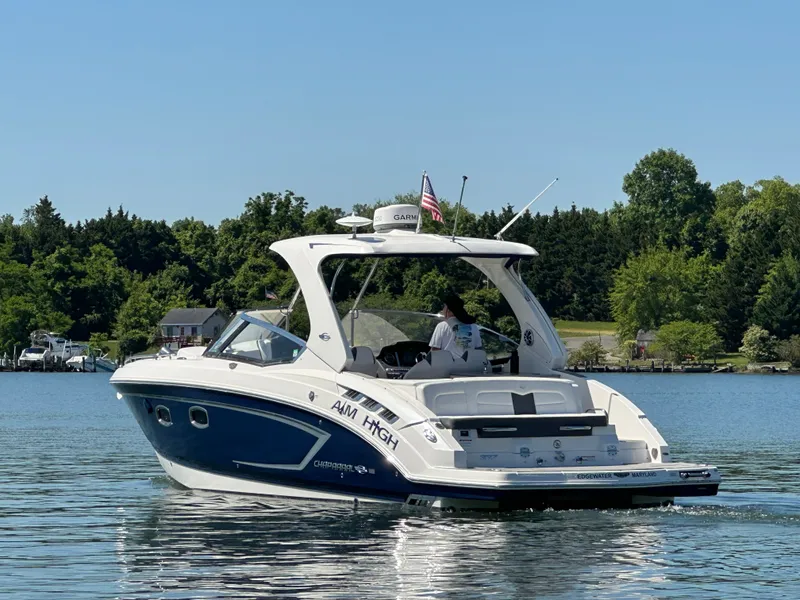Slide: The Image of A 2016 Chaparral 337 SSX boat cruising on a calm lake with a wooded shoreline. - 33