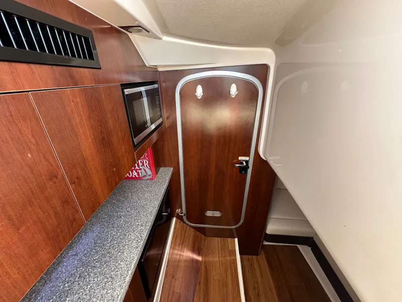 Slide: The Image of Interior of a 2016 Chaparral 337 SSX with wood paneling and a door. - 35