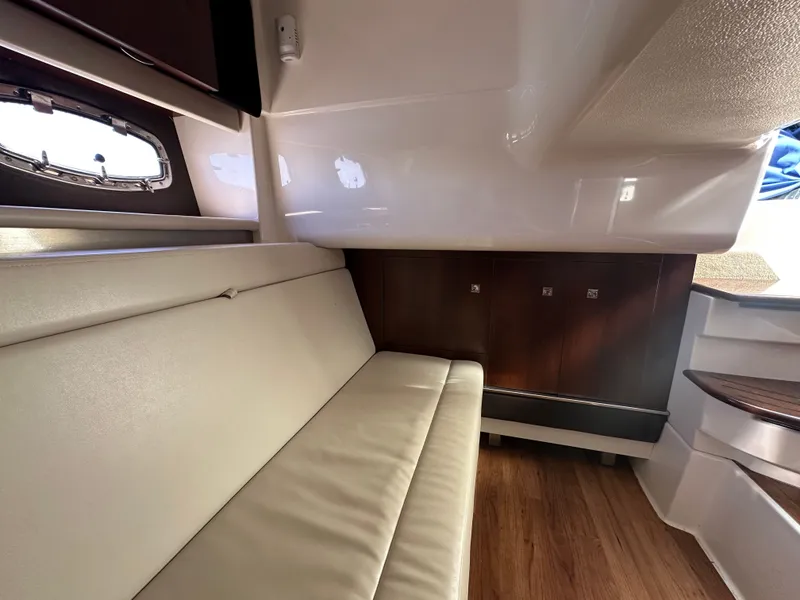 Slide: The Image of Interior of a 2016 Chaparral 337 SSX with beige sofa and wooden flooring. - 37