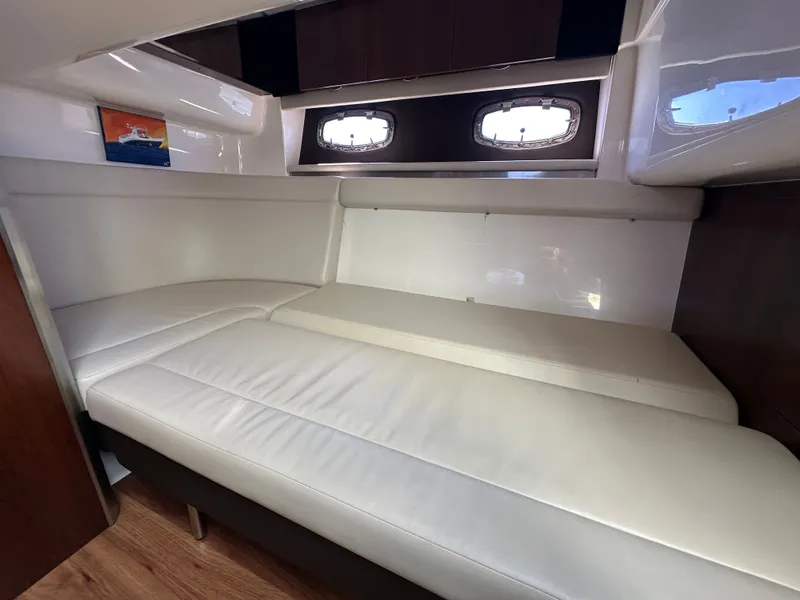 Slide: The Image of Interior of a 2016 Chaparral 337 SSX with white upholstery and portholes. - 46