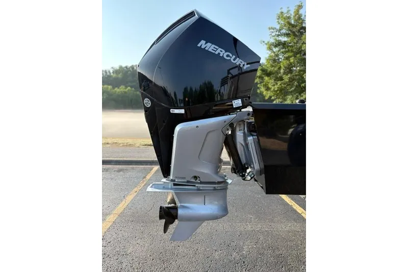 Slide: The Image of 2024 Regency 250 DL3 boat with Mercury outboard motor in a parking lot. - 12