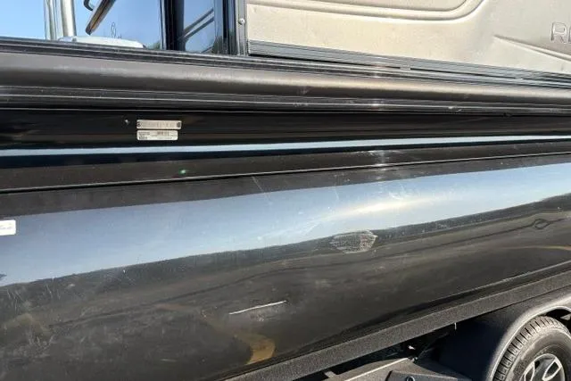 Slide: The Image of 2024 Regency 250 DL3 boat exterior with sleek black finish and visible trailer. - 15