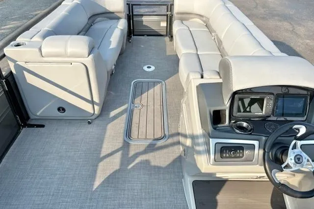 Slide: The Image of 2024 Regency 250 DL3 pontoon boat interior with plush seating and modern dashboard. - 16