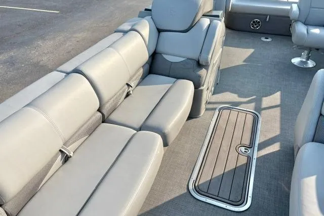 Slide: The Image of 2024 Regency 250 DL3 pontoon boat interior with gray seating and deck hatch. - 18