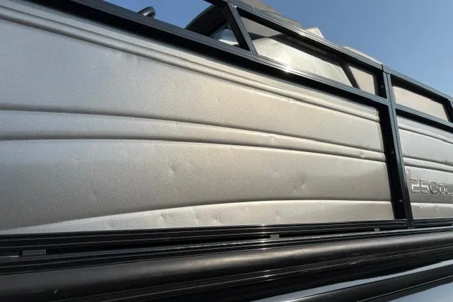 Slide: The Image of 2024 Regency 250 DL3 pontoon boat side view with sleek metallic finish. - 21