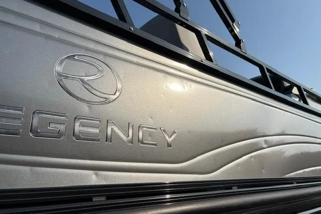 Slide: The Image of 2024 Regency 250 DL3 boat exterior with logo, showcasing sleek metallic design. - 22