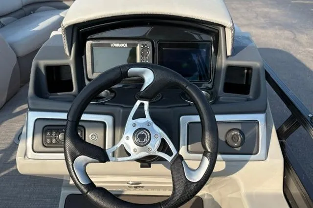 Slide: The Image of 2024 Regency 250 DL3 boat dashboard with steering wheel and Lowrance navigation system. - 23