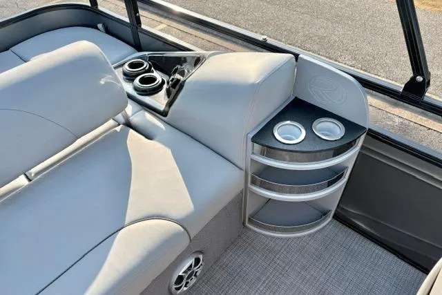 Slide: The Image of 2024 Regency 250 DL3 boat interior with plush seating and built-in cup holders. - 33