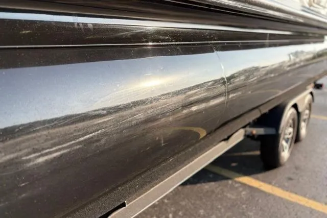 Slide: The Image of 2024 Regency 250 DL3 boat hull with visible scratches and reflections in sunlight. - 46