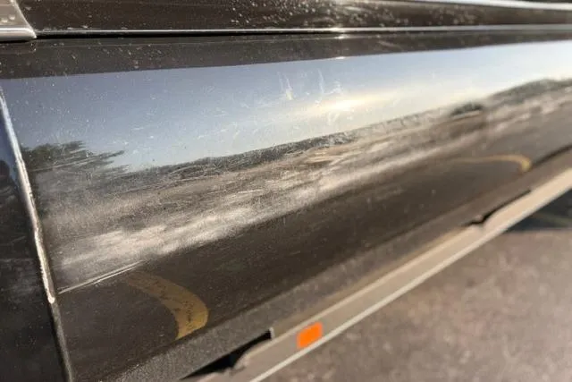 Slide: The Image of Close-up of a 2024 Regency 250 DL3 boat exterior with reflective surface and minor scratches. - 47