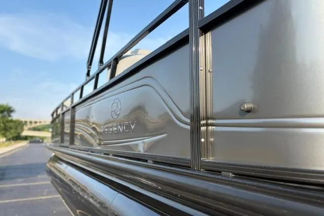 Slide: The Image of 2024 Regency 250 DL3 pontoon boat, sleek metallic exterior, close-up view. - 49