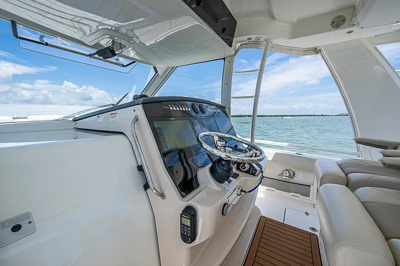 Slide: The Image of 2022 Boston Whaler 420 Outrage helm with modern controls and ocean view. - 11