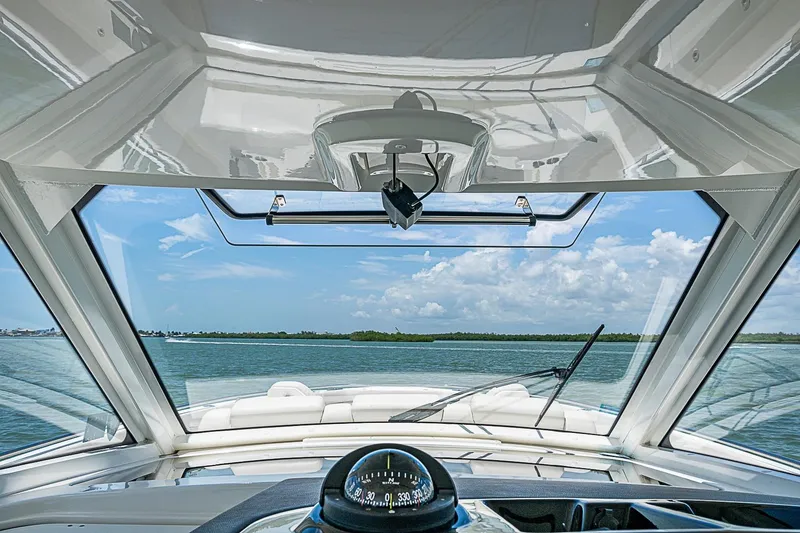 Slide: The Image of Interior view from a 2022 Boston Whaler 420 Outrage boat, showcasing the helm and ocean scenery. - 13
