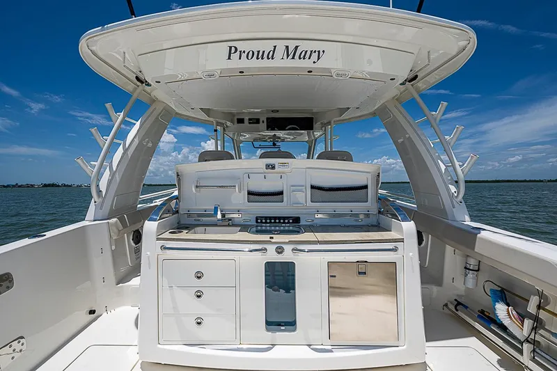 Slide: The Image of Boston Whaler 420 Outrage 2022 boat deck with "Proud Mary" name, ocean backdrop. - 14